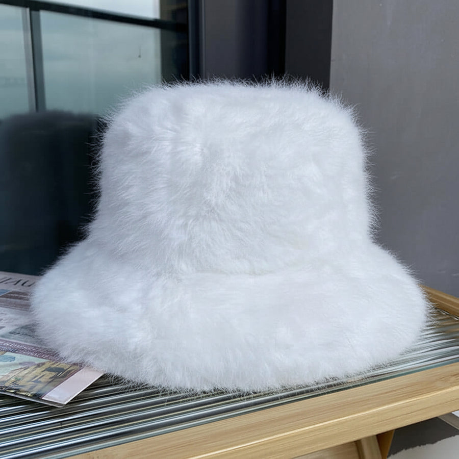 Two fluffy, colorful slippers on a glass surface with a blurred background