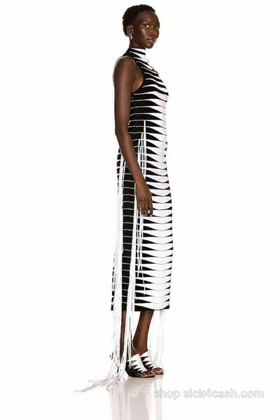Woman wearing a black and white striped dress with sheer panels on a white background