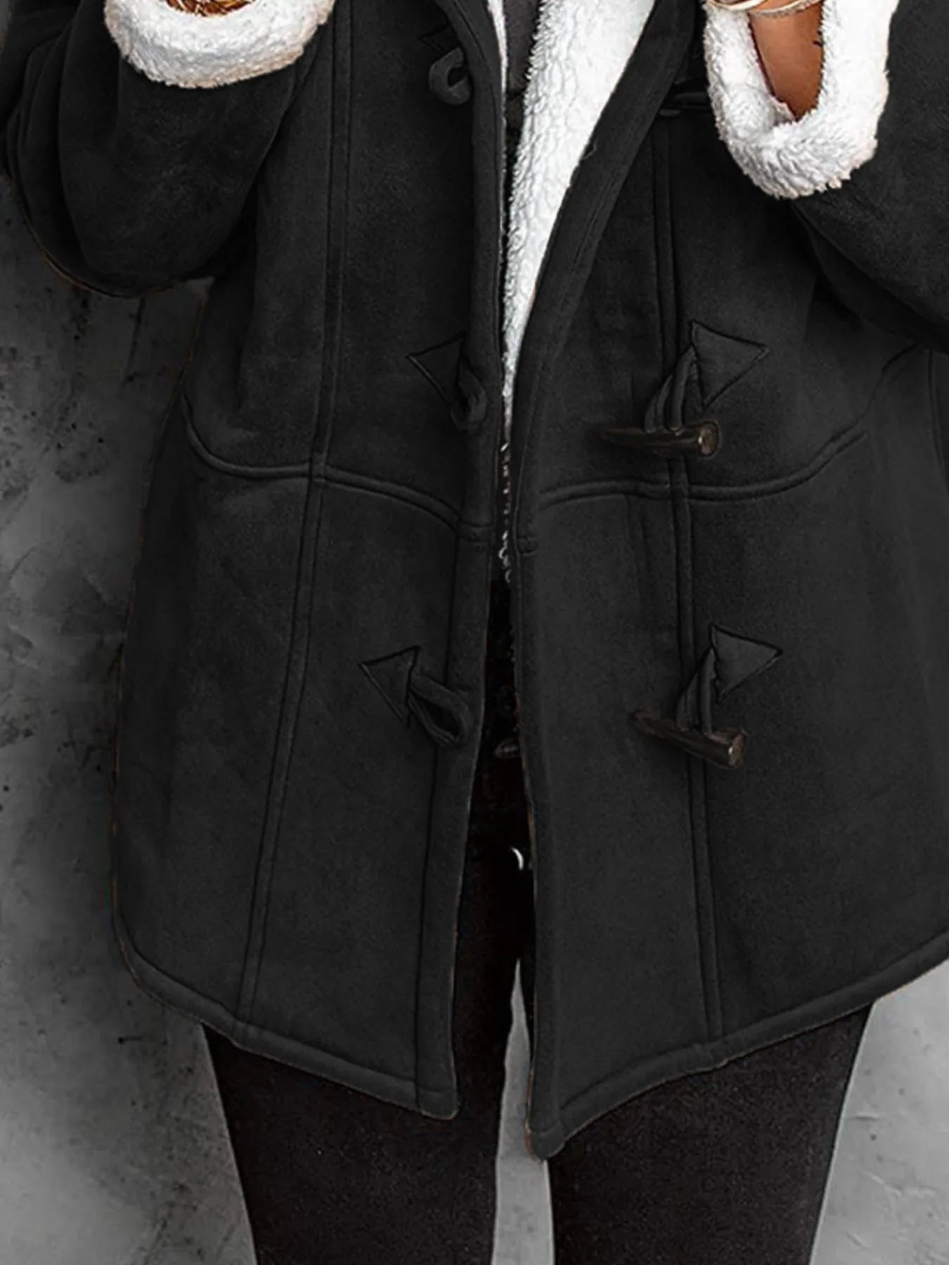"Black sherpa toggle coat with hood on neutral background"