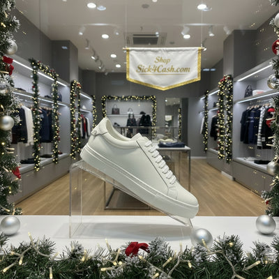 White sneaker on a black and white surface with a neutral background