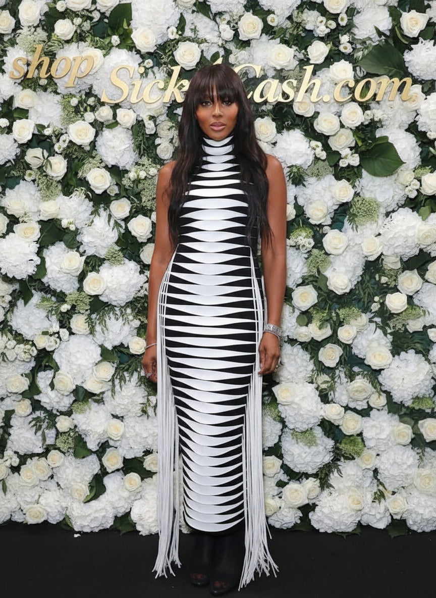 Woman in a black and white dress standing in front of a floral wall with 'shop Sick Cash.com' text.