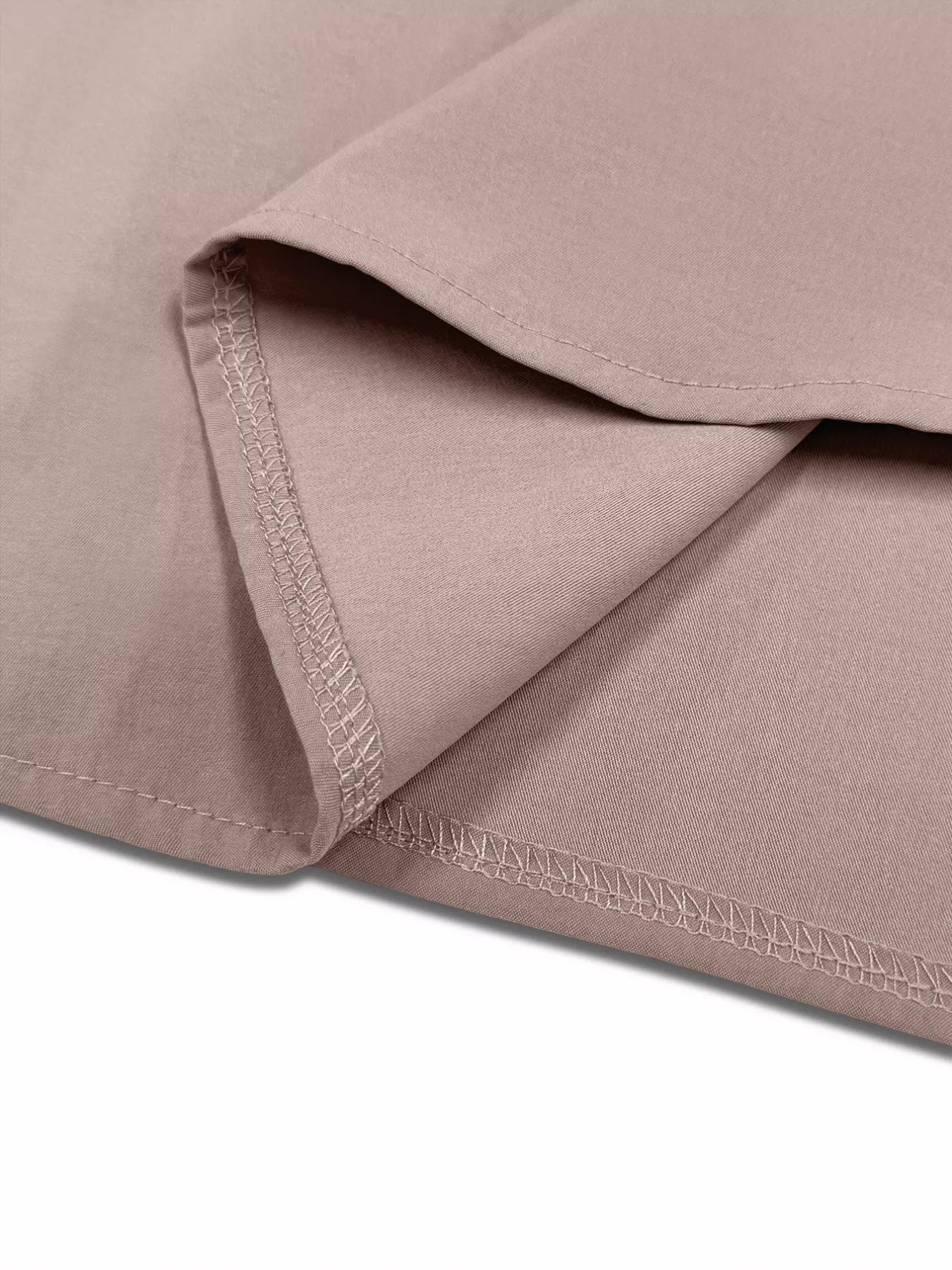 Close-up of a folded piece of fabric with visible stitching on a white background