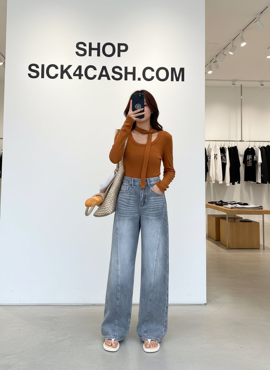 Person taking a mirror selfie in a store wearing a brown top and blue jeans, with 'Sick4Cash' branding.