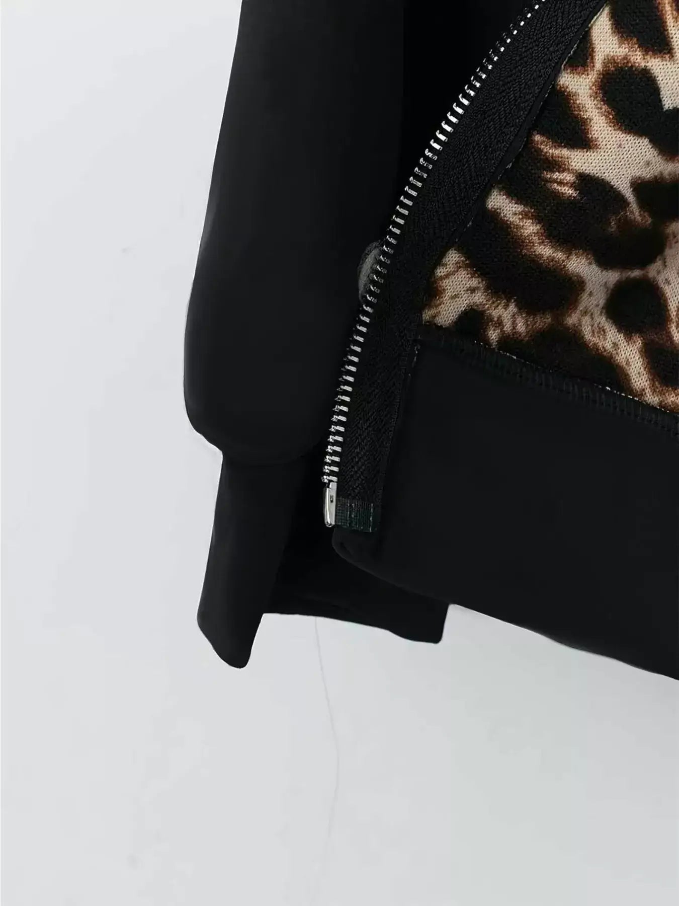 Black jacket with leopard print lining on a white background
