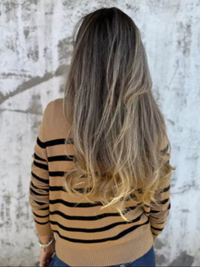 Person wearing a striped sweater with a neutral background