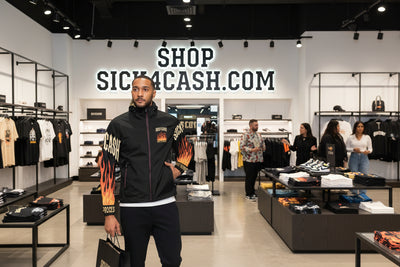 Black jacket with flame designs and text on sleeves, worn by a person.