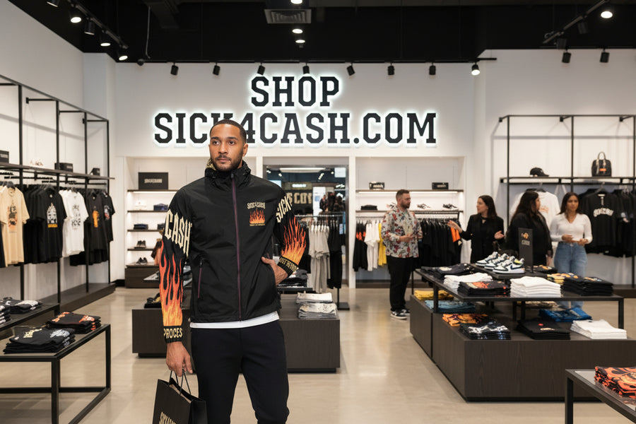 Black jacket with flame designs and text on sleeves, worn by a person.