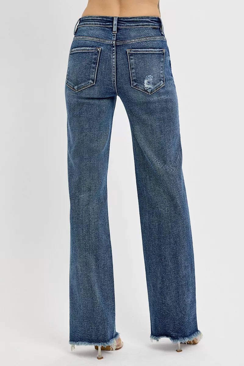 Blue jeans with a distressed back pocket design on a white background