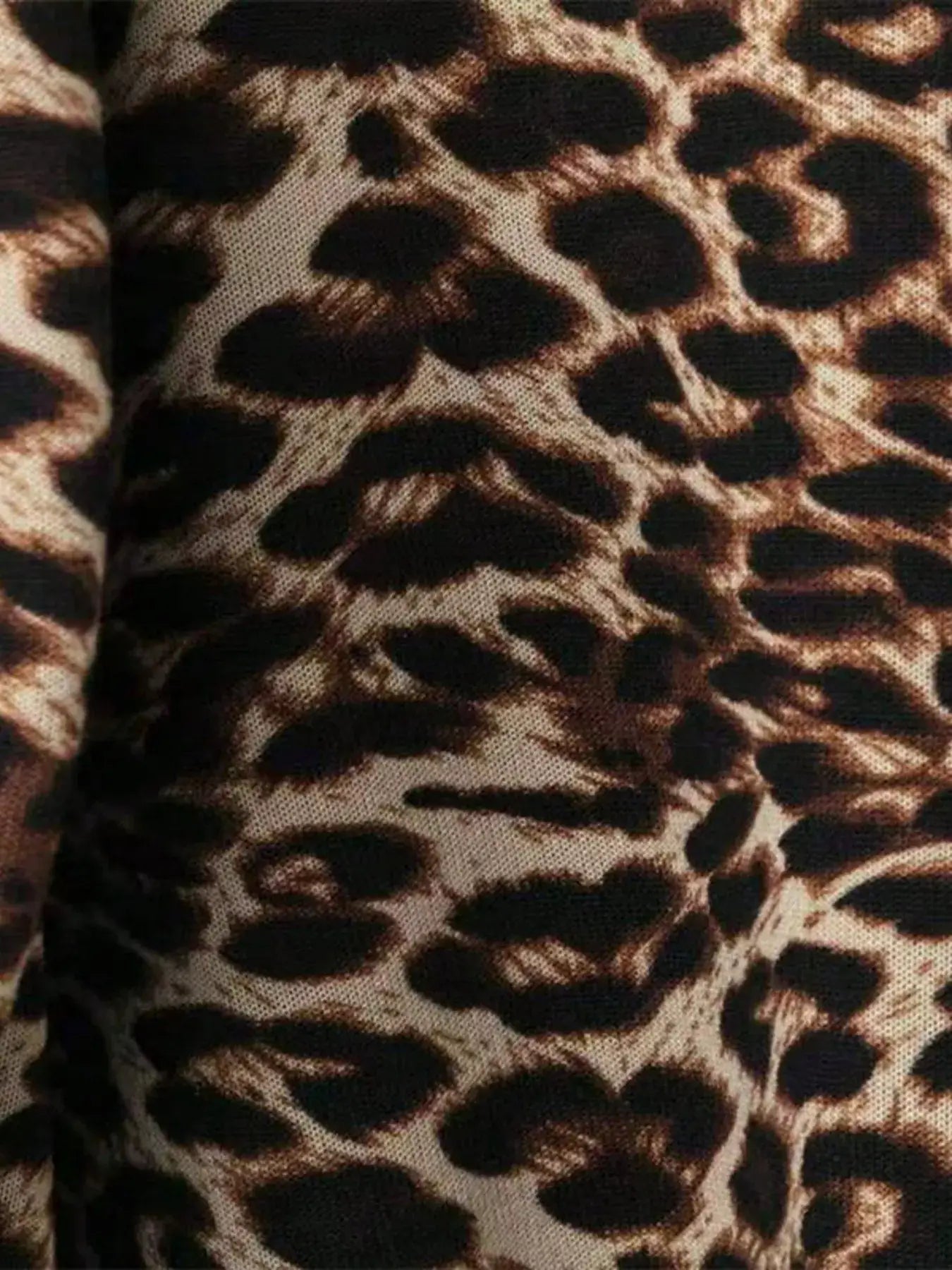 Close-up of leopard print fabric with brown and black spots.