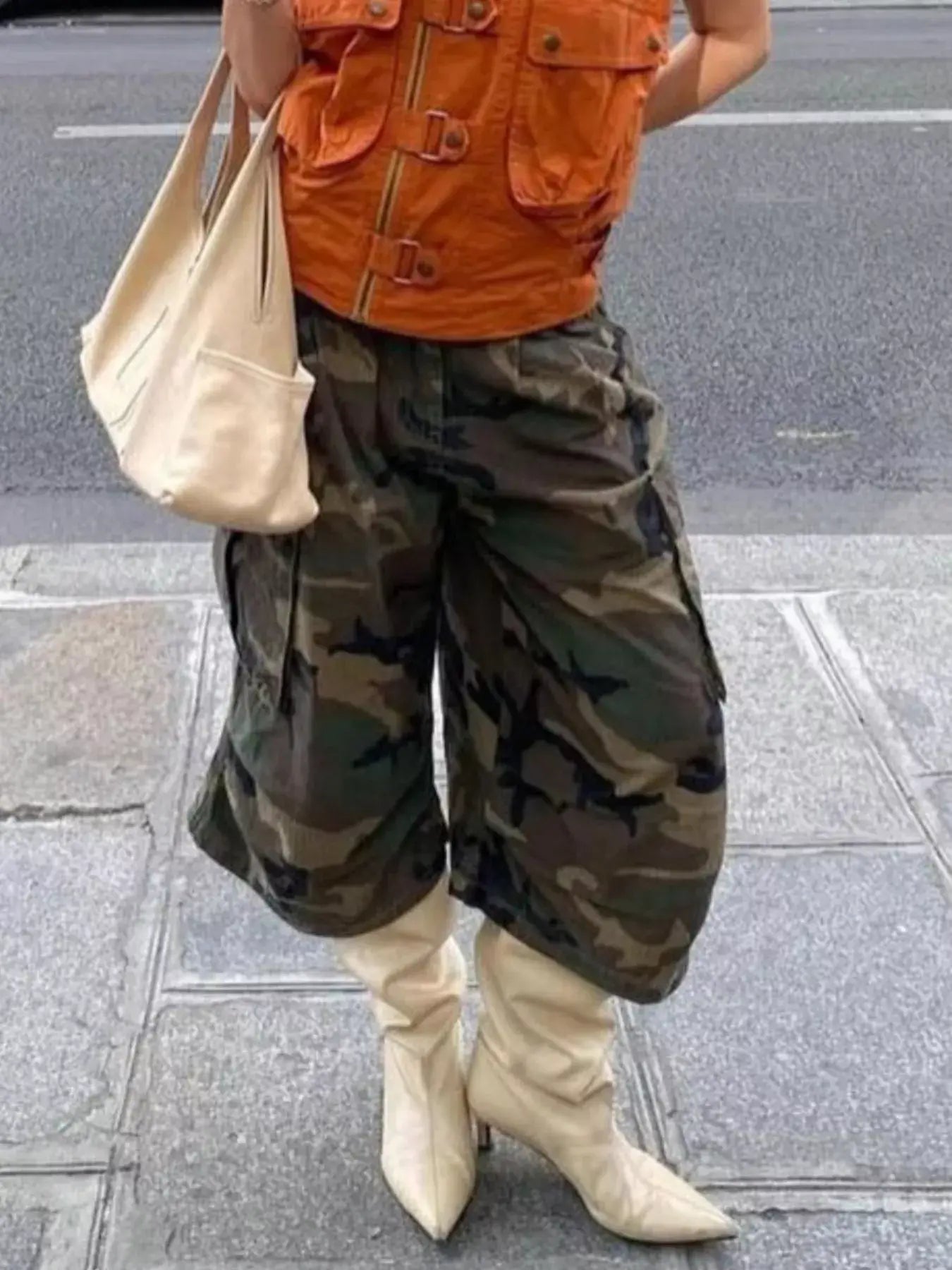 Stylish outfit featuring Camouflage Cargo Cropped Pants paired with a fashionable orange vest and beige boots.
