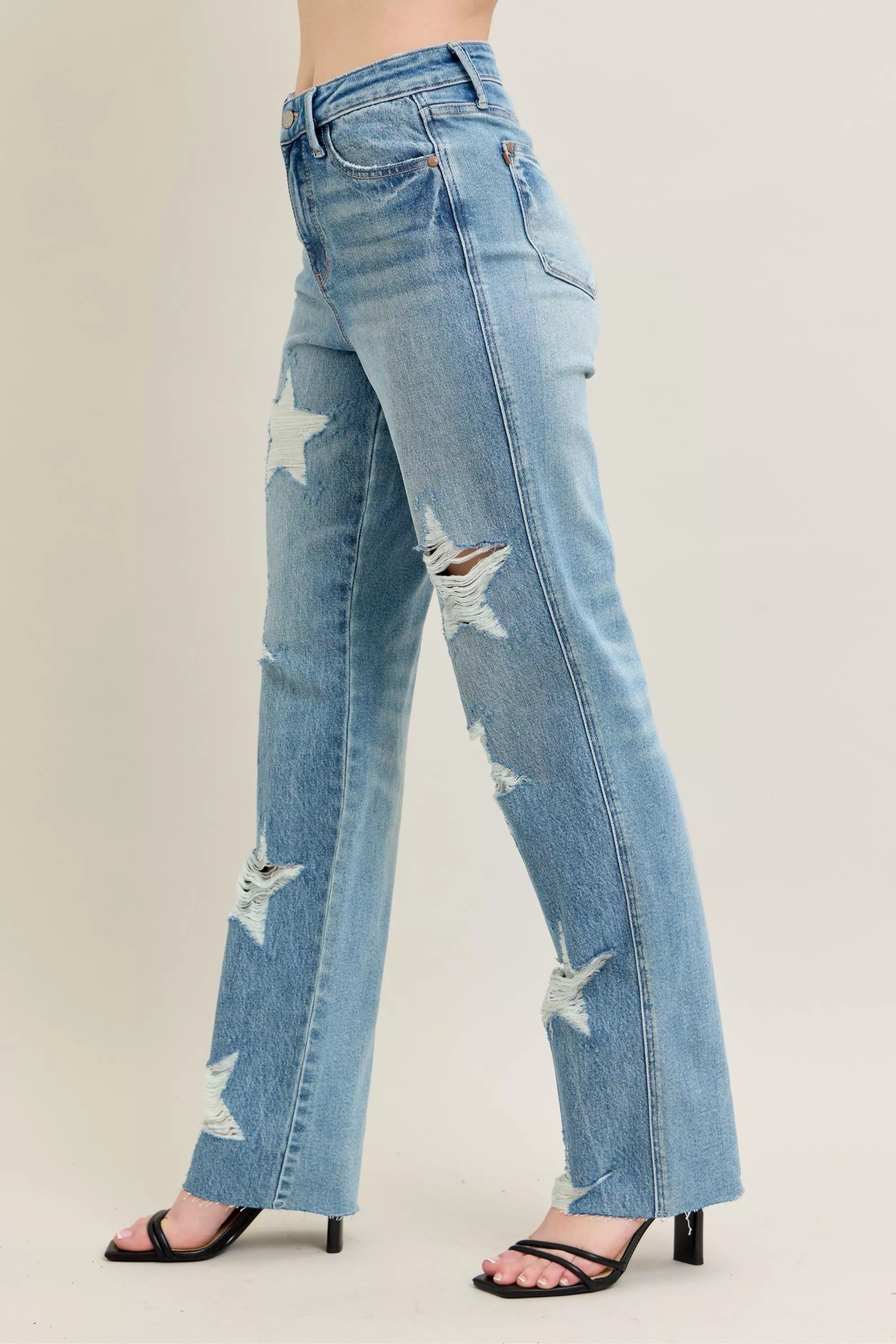 Light blue distressed jeans worn by a person on a plain background