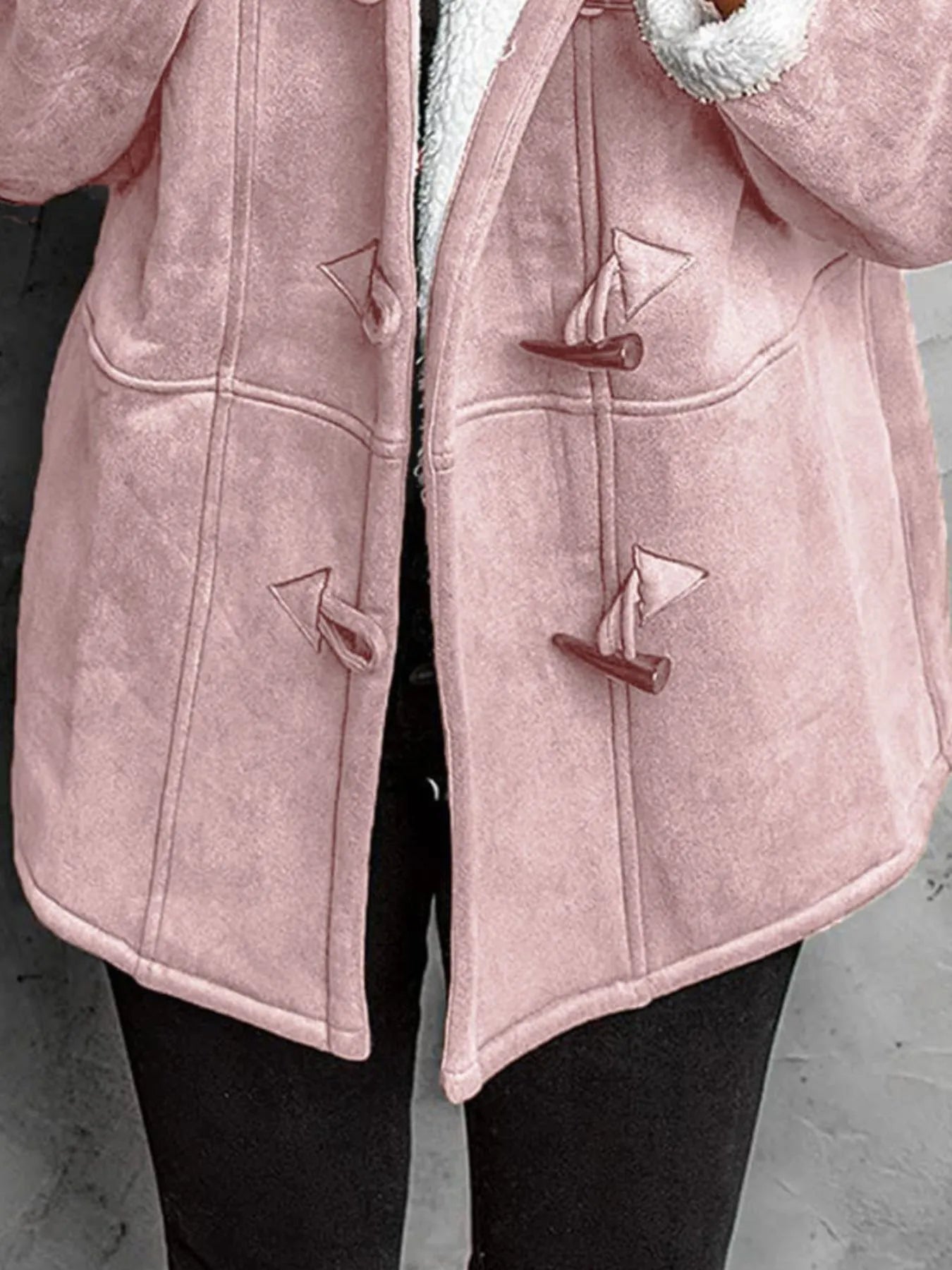 "Close-up of pink toggle coat button detail"