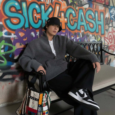 Person sitting on a bench with colorful graffiti wall in the background