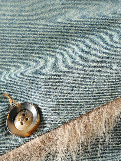 Close-up of a button on denim fabric with a natural fiber edge.