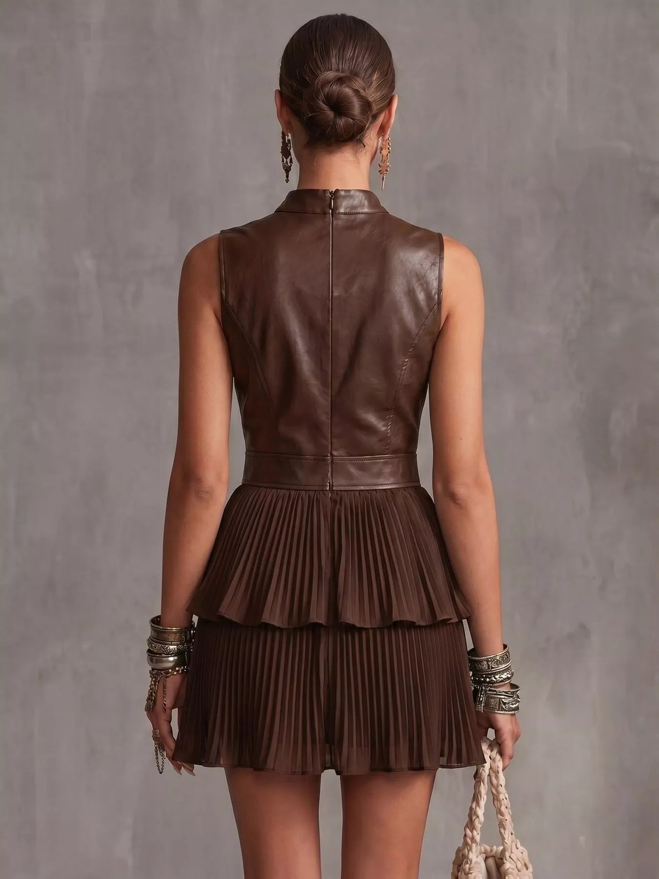 Back view of Sleeveless Faux Leather Look Pleated Mini Dress in brown with layered pleats and seam detailing.