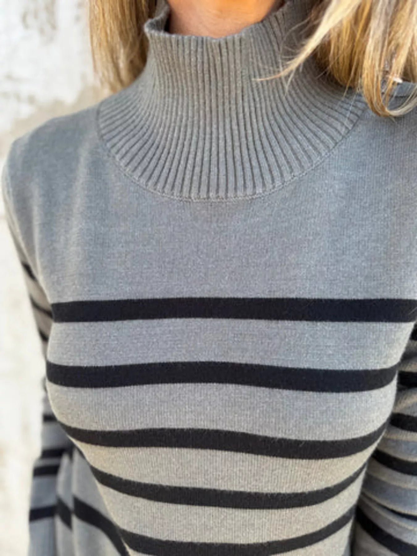 Gray turtleneck sweater with black horizontal stripes.