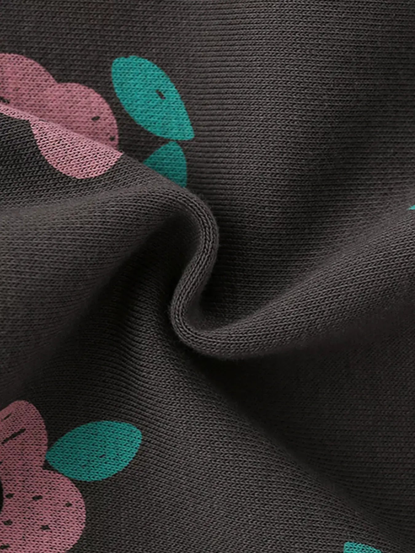 Close-up of fabric showing Children's Floral Print Crew Neck Sweatshirt with floral design and ribbed texture.